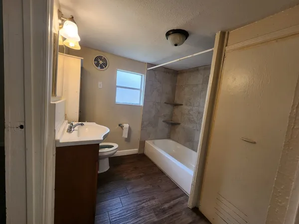 a bathroom with a sink a toilet and shower
