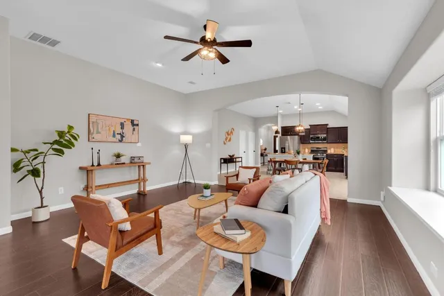 a living room with furniture a ceiling fan and a rug