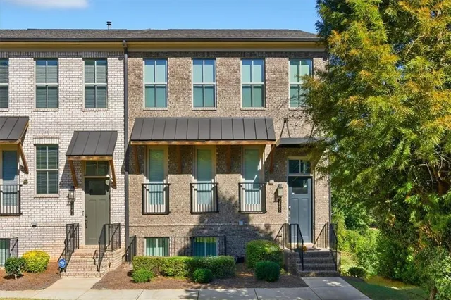 a front view of a building with a garden and plants