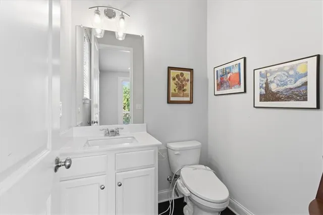 a bathroom with a toilet a sink and mirror