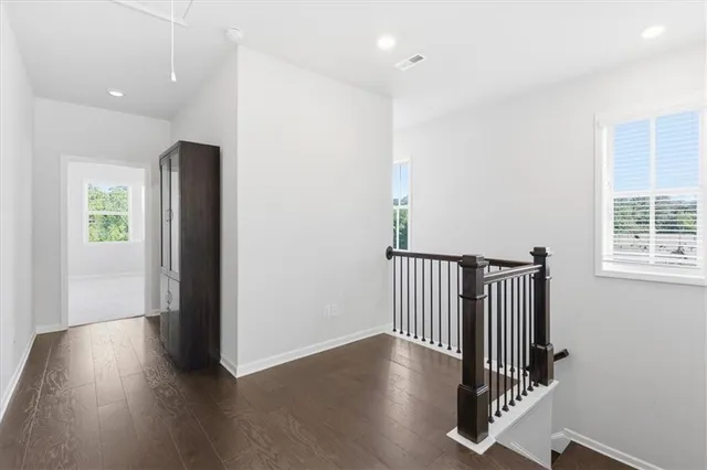 an entryway with wooden floor and windows