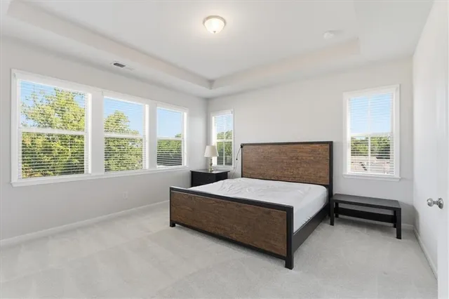 a spacious bedroom with a bed and a large window