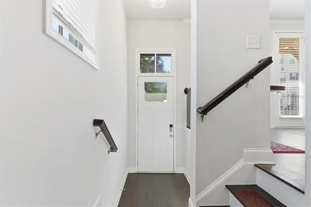 a view of hallway with stairs and wooden floor