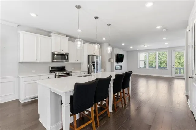 a kitchen with kitchen island granite countertop a sink a counter space appliances and cabinets