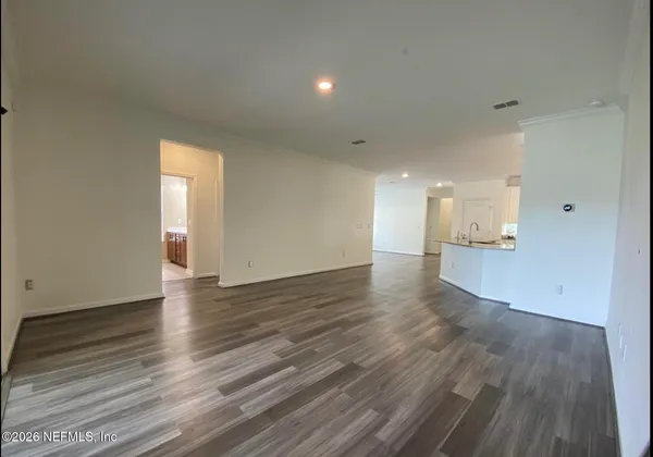 a view of empty room with wooden floor