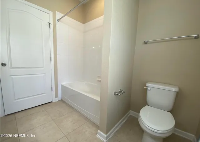 a white toilet sitting next to a bath tub