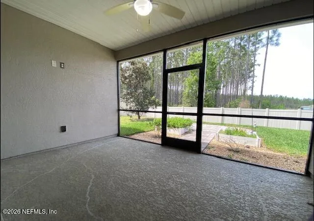 an empty room with floor to ceiling windows and yard