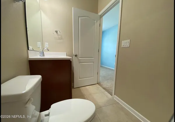 a bathroom with a sink a toilet a mirror and vanity
