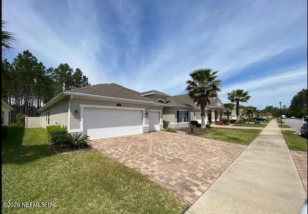 a front view of a house with a yard and potted plants