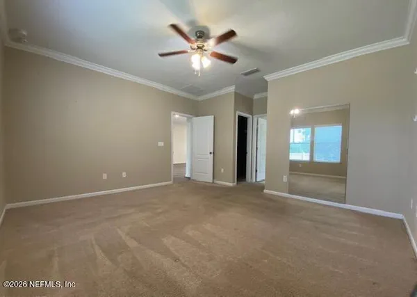 an empty room with ceiling fan and window