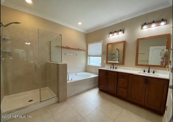 a bathroom with a double vanity sink mirror and shower