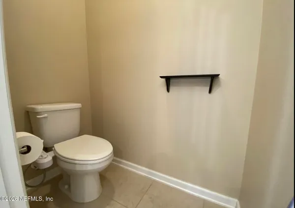 a white toilet sitting next to a white wall