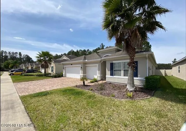 a front view of a house with a yard and palm tree