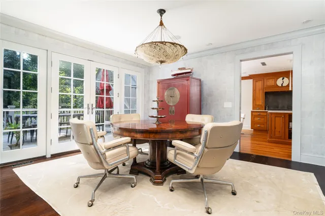 a dining room with furniture a chandelier and wooden floor