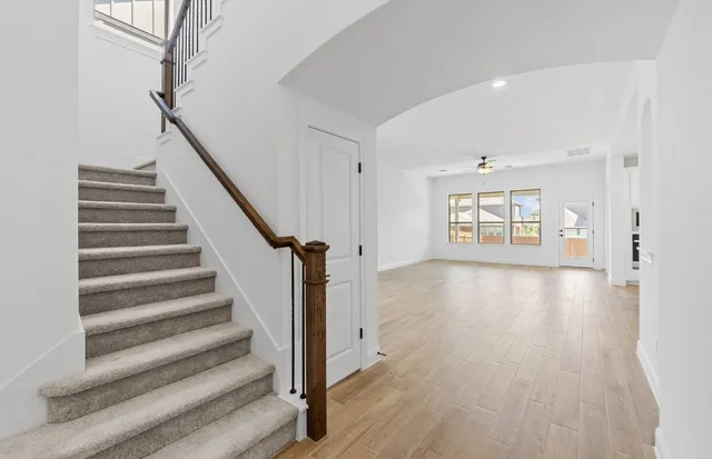 a view of a kitchen with kitchen island a sink wooden floor and a refrigerator