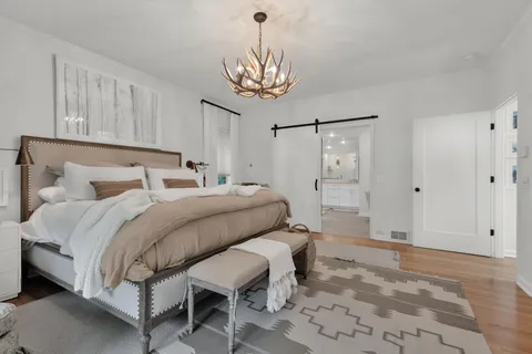 a bedroom with a bed and a chandelier