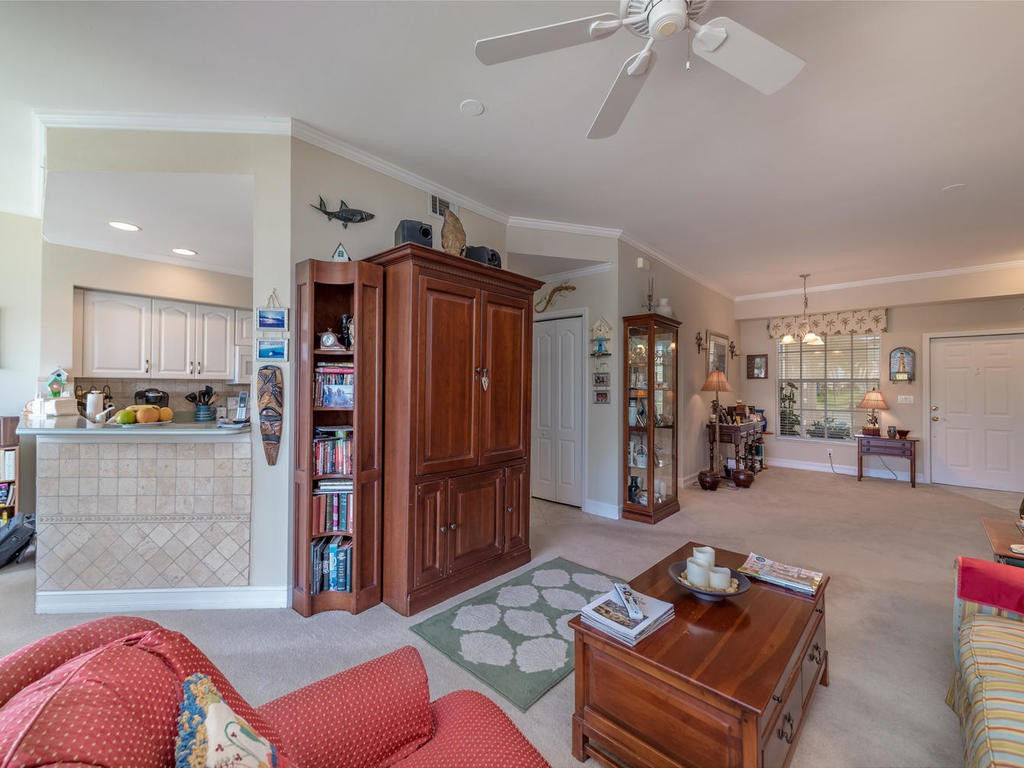 237 Sunrise Cay, Unit 101 Naples, FL 34114 - Photo 14 of 18 a living room with furniture and gym equipment