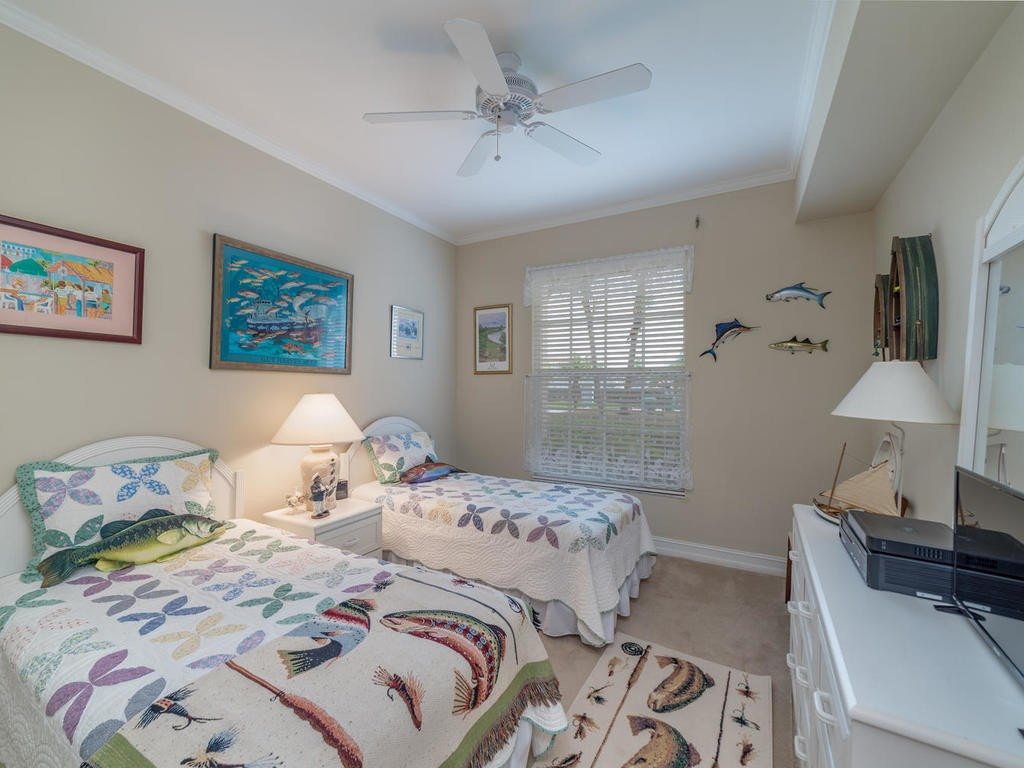 237 Sunrise Cay, Unit 101 Naples, FL 34114 - Photo 15 of 18 a bedroom with a bed and wooden floor