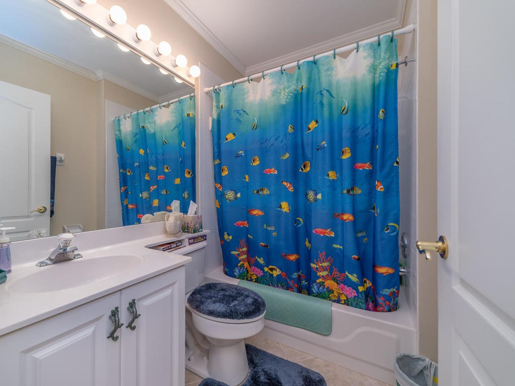 237 Sunrise Cay, Unit 101 Naples, FL 34114 - Photo 16 of 18 a bathroom with a sink a toilet and shower curtain