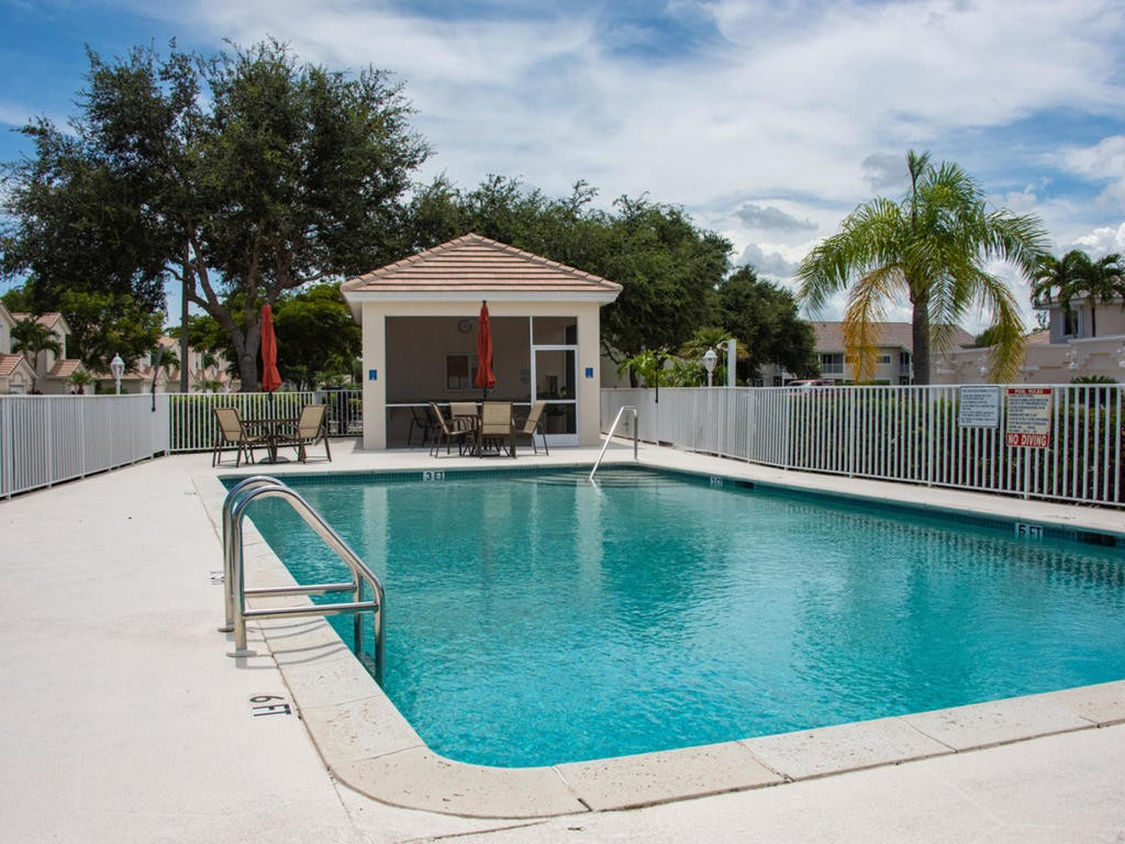 237 Sunrise Cay, Unit 101 Naples, FL 34114 - Photo 17 of 18 a swimming pool with outdoor seating and yard