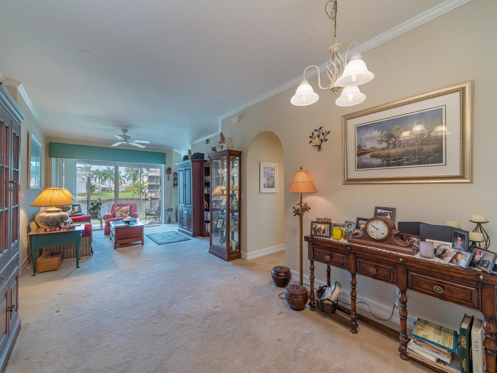237 Sunrise Cay, Unit 101 Naples, FL 34114 - Photo 4 of 18 a living room with furniture and chandelier