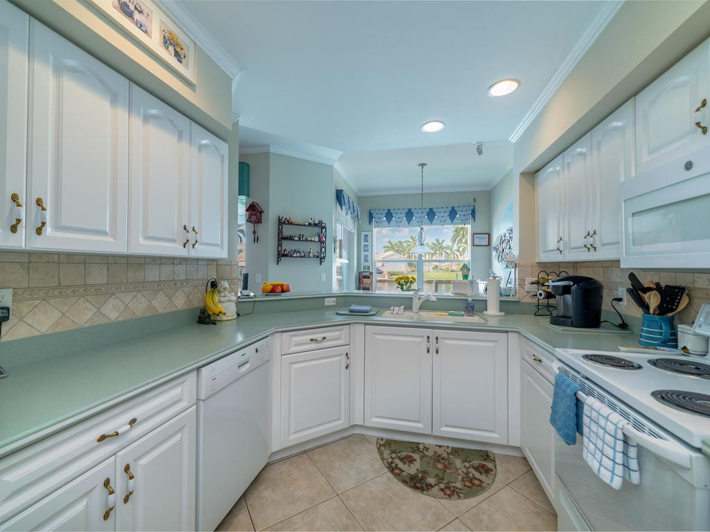 237 Sunrise Cay, Unit 101 Naples, FL 34114 - Photo 6 of 18 a kitchen with sink and cabinets