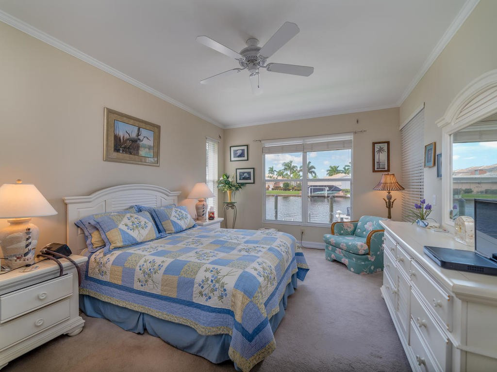237 Sunrise Cay, Unit 101 Naples, FL 34114 - Photo 8 of 18 a bedroom with a large bed and windows
