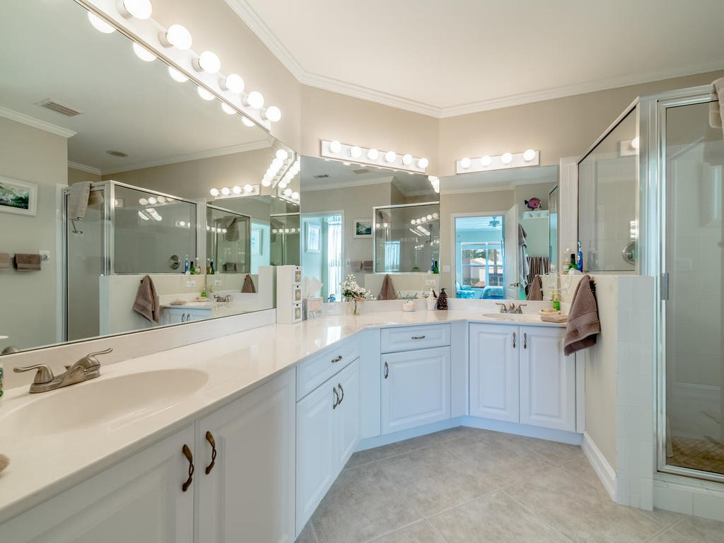 237 Sunrise Cay, Unit 101 Naples, FL 34114 - Photo 9 of 18 a spacious bathroom with a double vanity sink mirror and shower