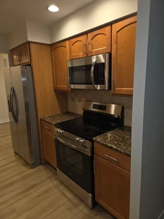 a kitchen with stainless steel appliances granite countertop a refrigerator and a stove top oven