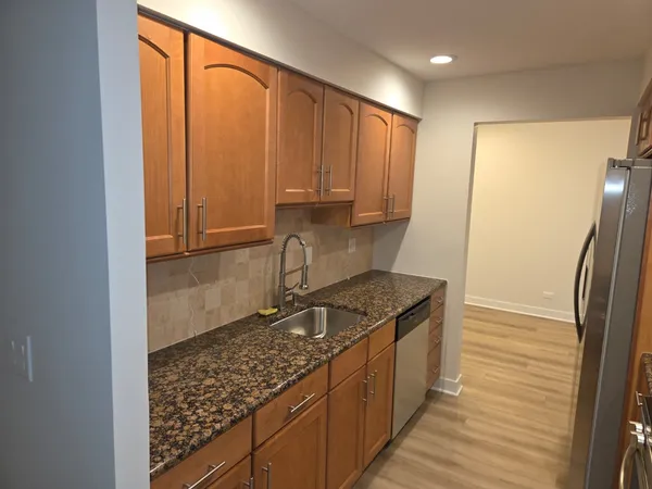 a kitchen with stainless steel appliances granite countertop a refrigerator and a sink