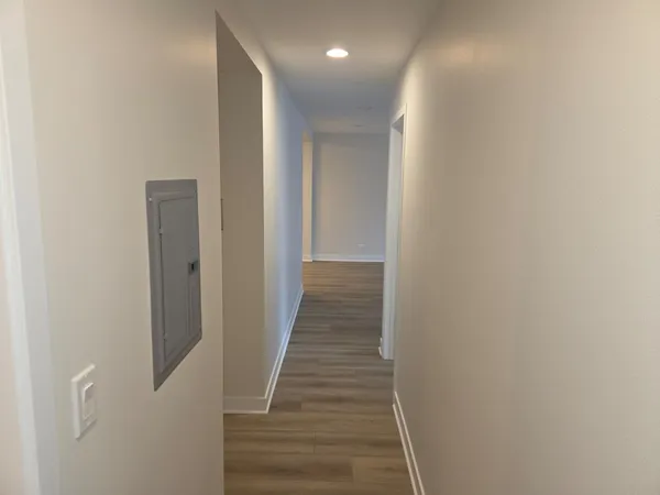 a view of a hallway with wooden floor and staircase