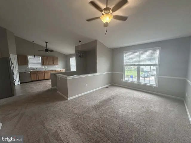 a view of a kitchen with furniture a ceiling fan and windows