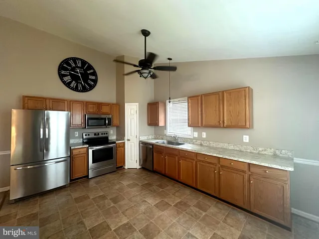 a kitchen with stainless steel appliances granite countertop a refrigerator and a sink
