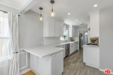 a kitchen with a sink a counter top space stainless steel appliances and cabinets