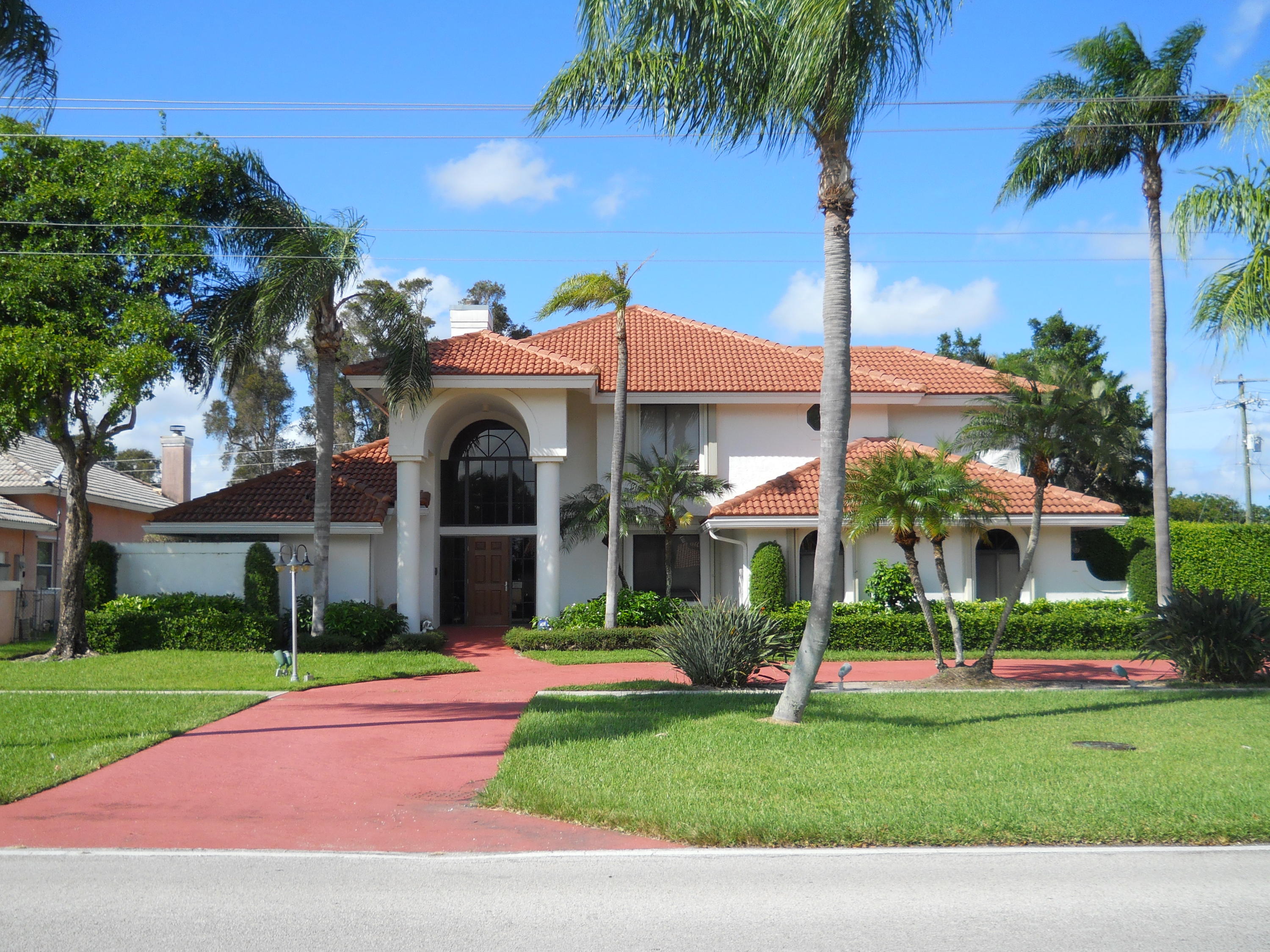 245 South Country Club Boulevard Boca Raton, FL 33487 - Photo 1 of 1 a front view of a house with a garden and trees