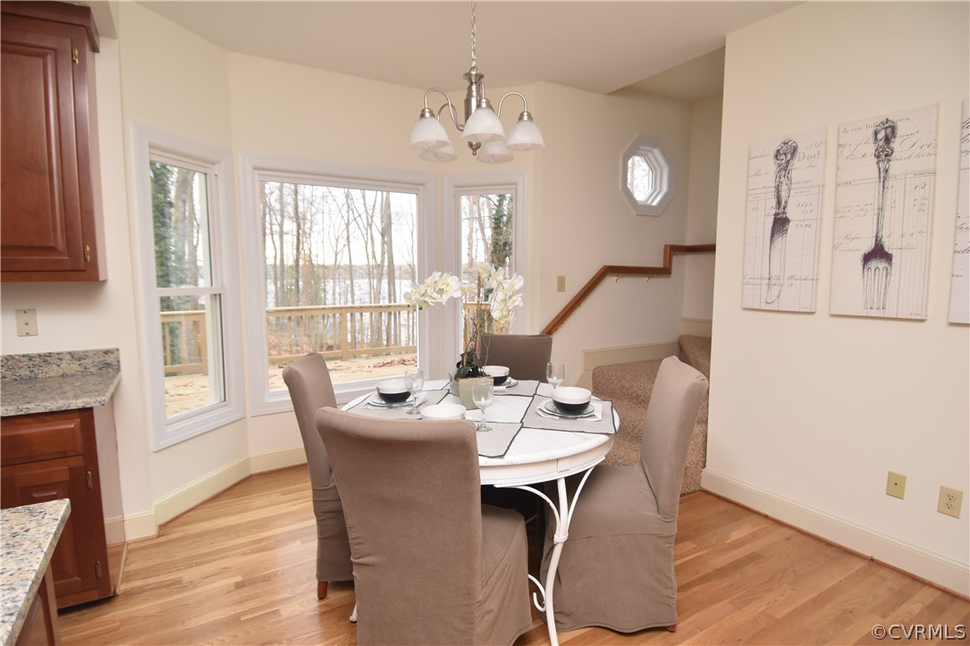 13806 Beechwood Point Road Midlothian, VA 23112 - Photo 22 of 48 a dining room with wooden floor a chandelier a wooden table and chairs