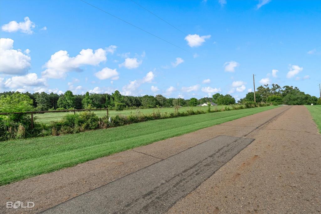 0 Twin Lakes Road Mansfield, LA 71052 - Photo 1 of 28 Gravel and asphalt driveway extending through expansive green lawns, bordered by a wire fence and mature trees