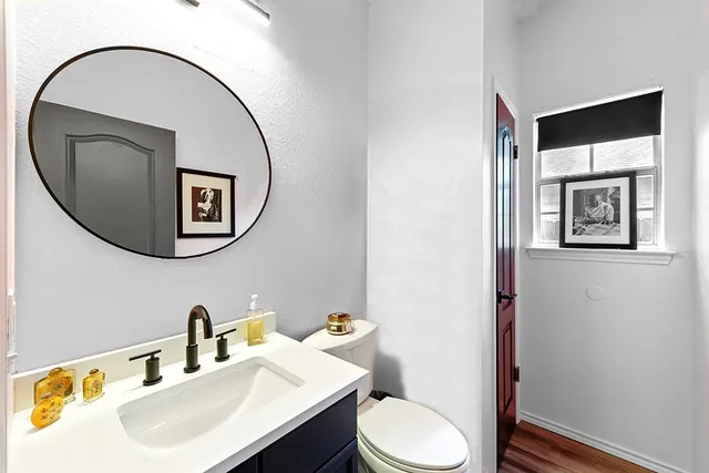 a bathroom with a toilet a sink and mirror