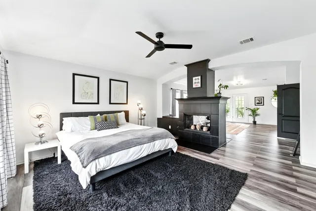 a bedroom with a bed wooden floor and a fireplace