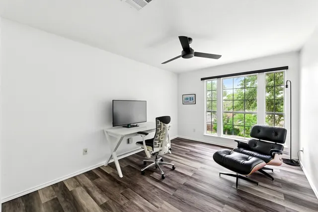 a view of a livingroom with workspace and a window