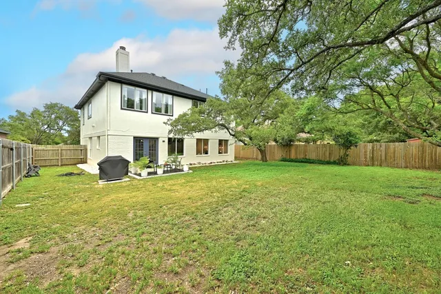 a view of a house with backyard and tree s