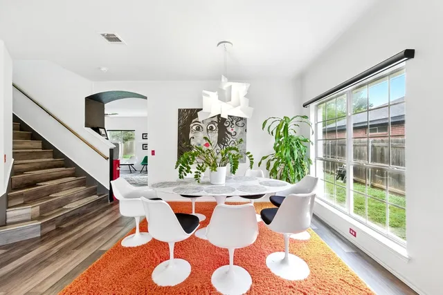 a view of a dining room with furniture a chandelier and wooden floor
