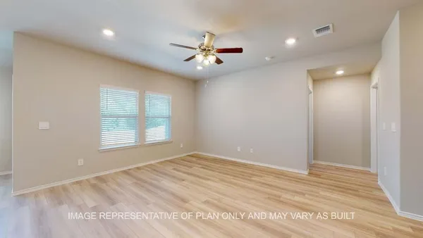 an empty room with chandelier fan and windows