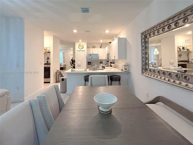 a living room with kitchen island a large window cabinets and stainless steel appliances