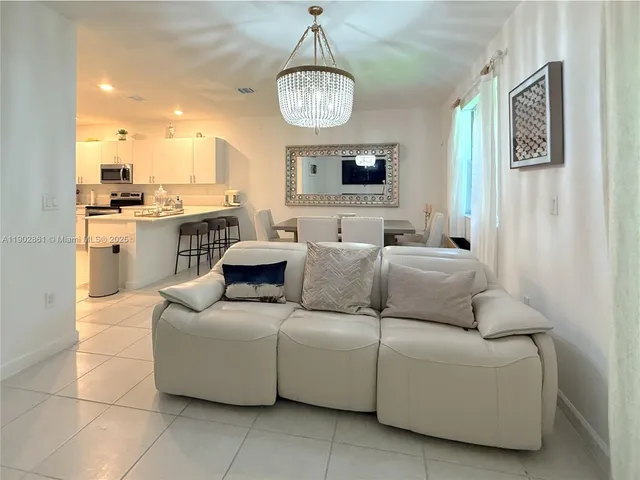 a living room with furniture a mirror and a table