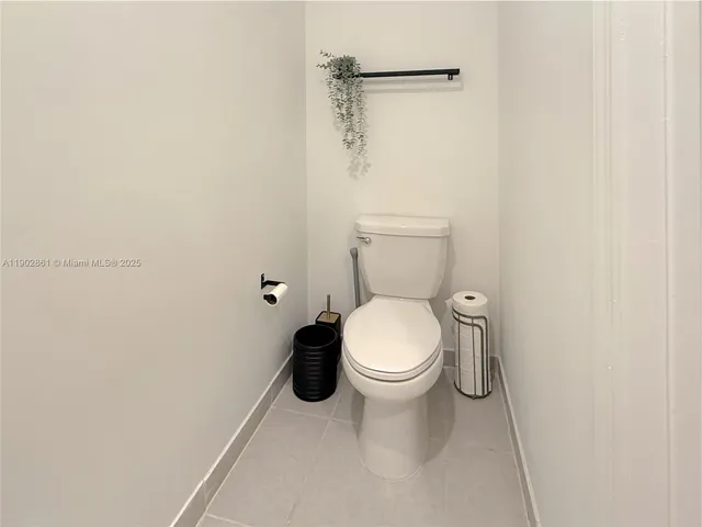 a white toilet sitting next to a white cabinet