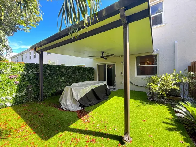 a view of back yard of the house with a patio