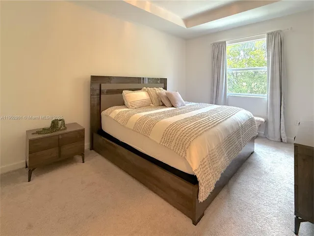 a large bed sitting in a bedroom next to a window