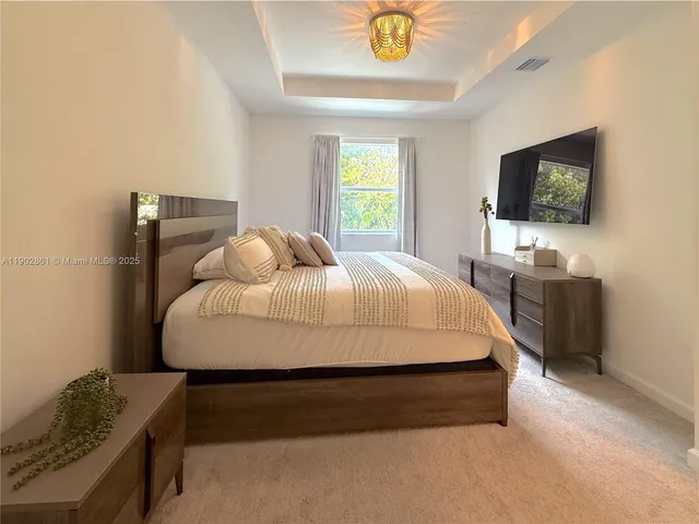 a bedroom with a bed and flat screen tv