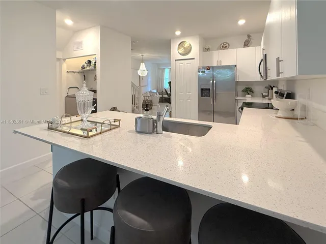 a kitchen with stainless steel appliances a sink and a refrigerator